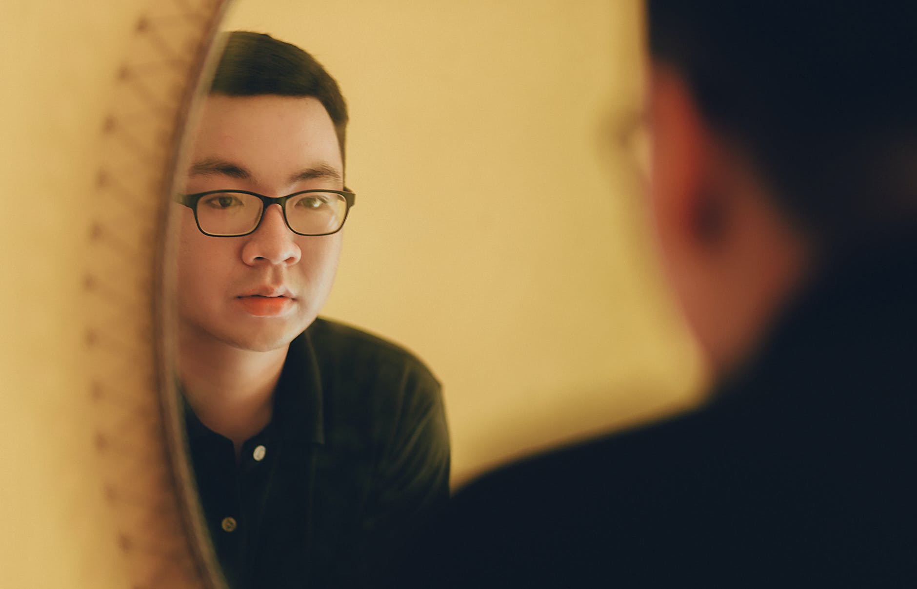 photo of man looking at the mirror