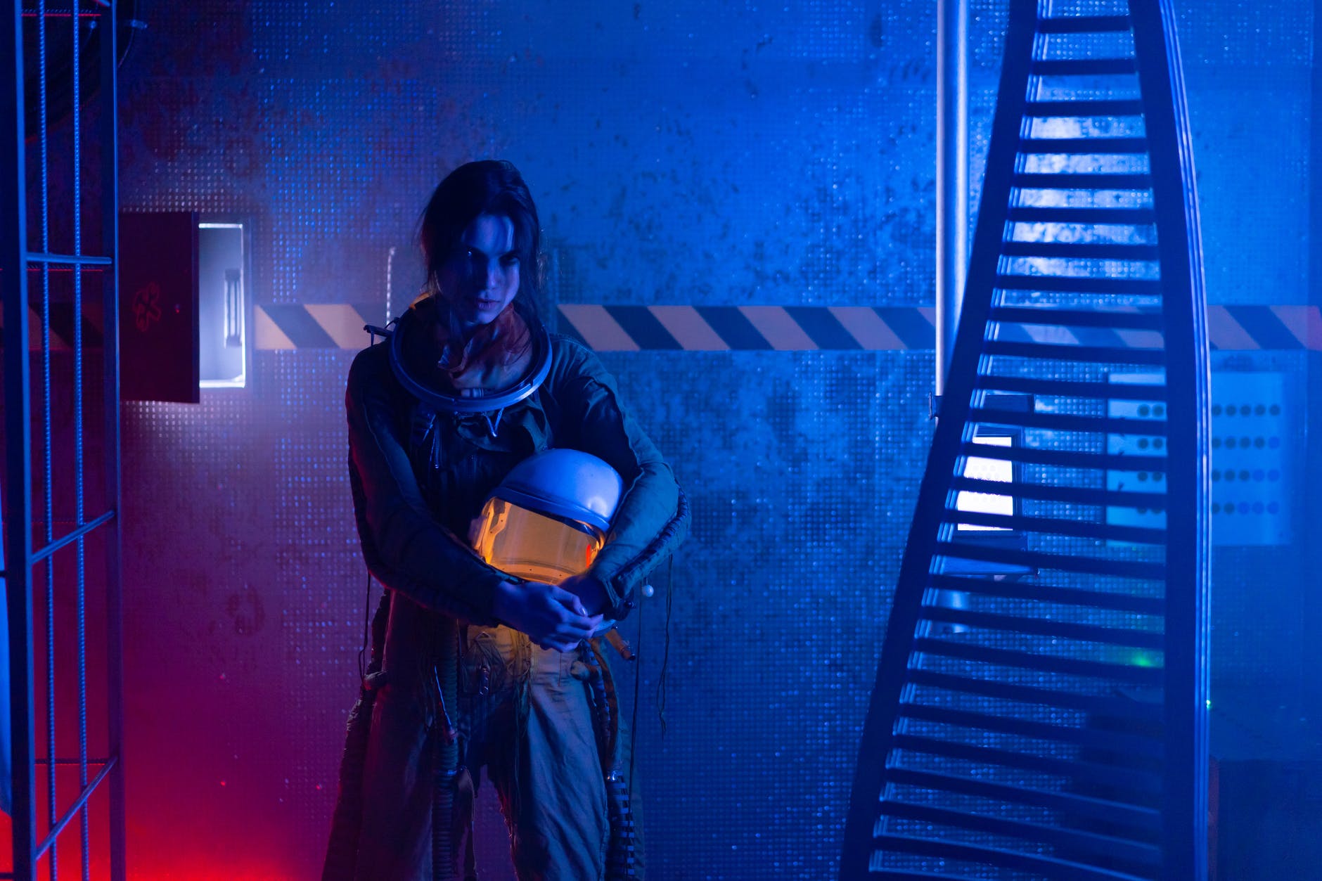 woman in spacesuit holding a helmet