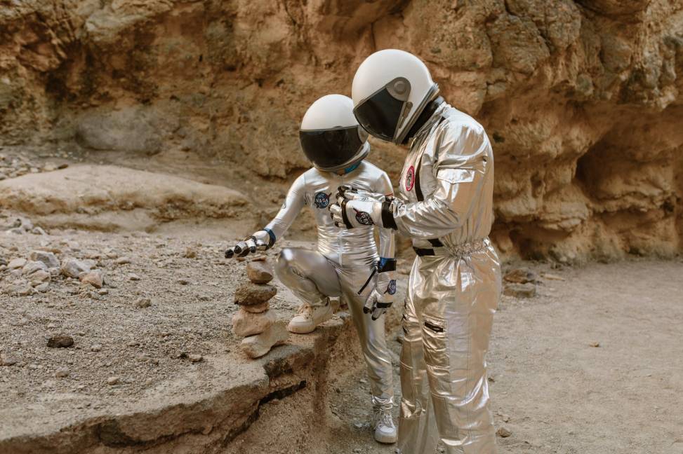 man in white and grey suit holding black and white motorcycle