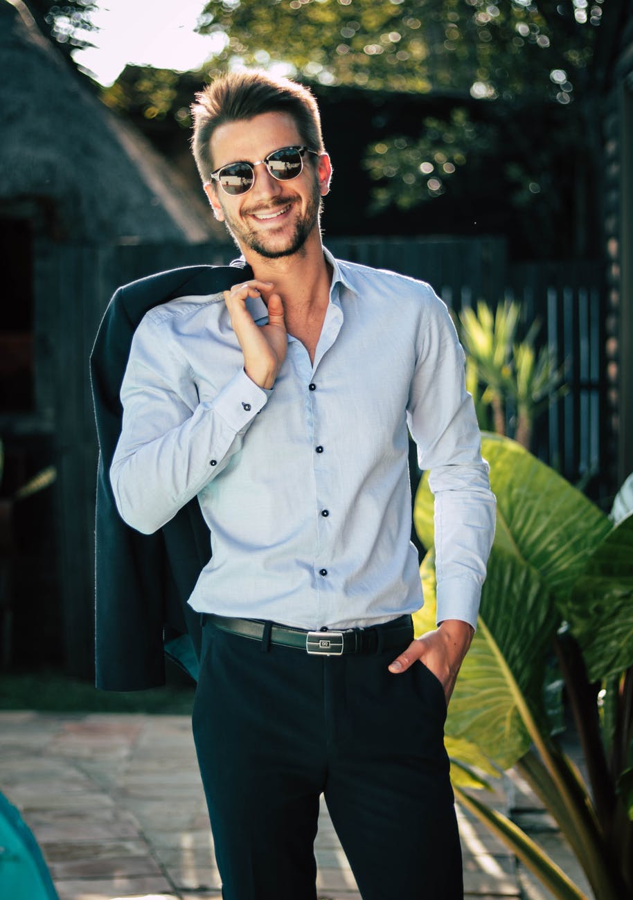 man in white dress shirt holding suit jacket