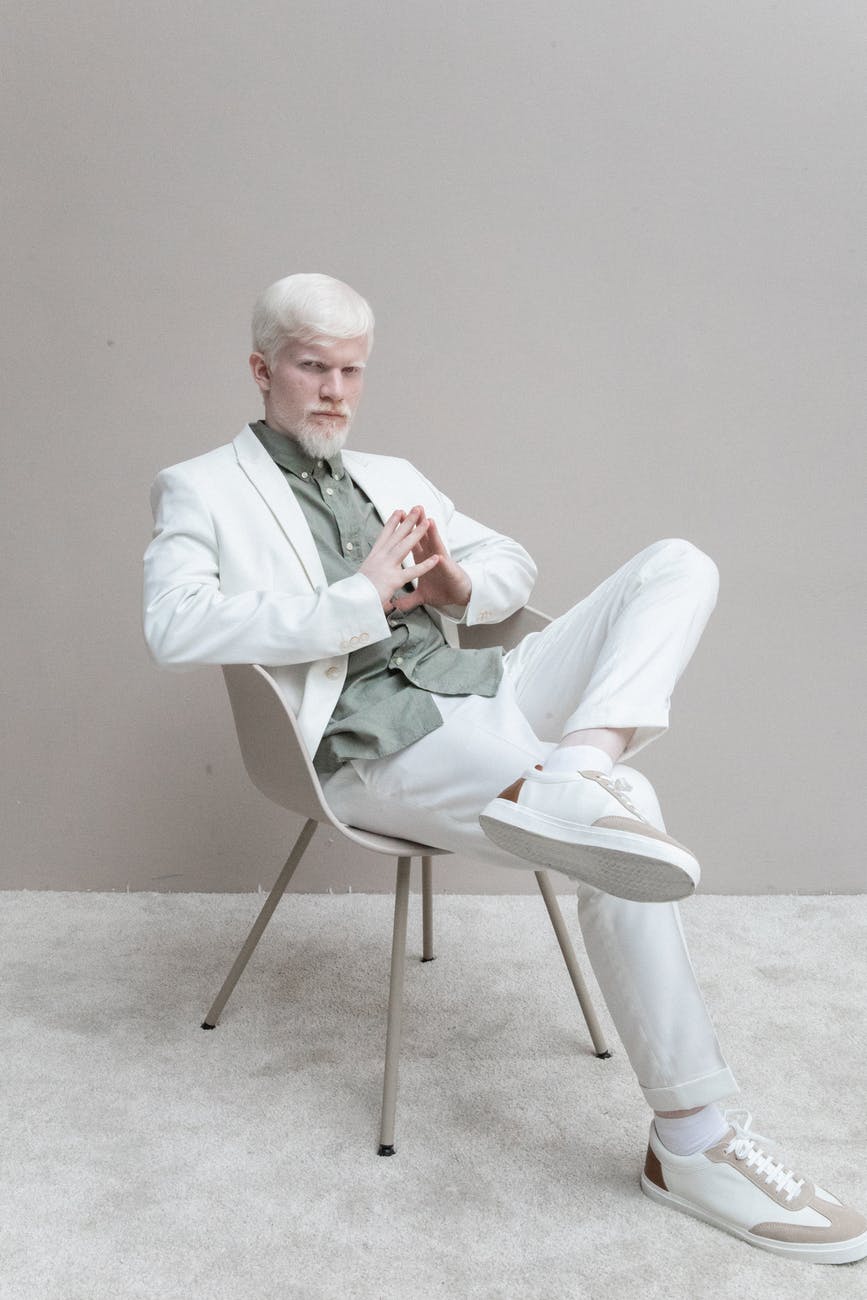 man in white suit sitting on white chair