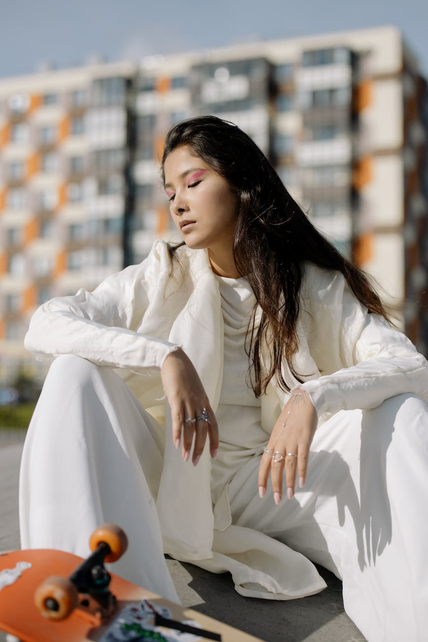 a woman in white suit with a skateboard