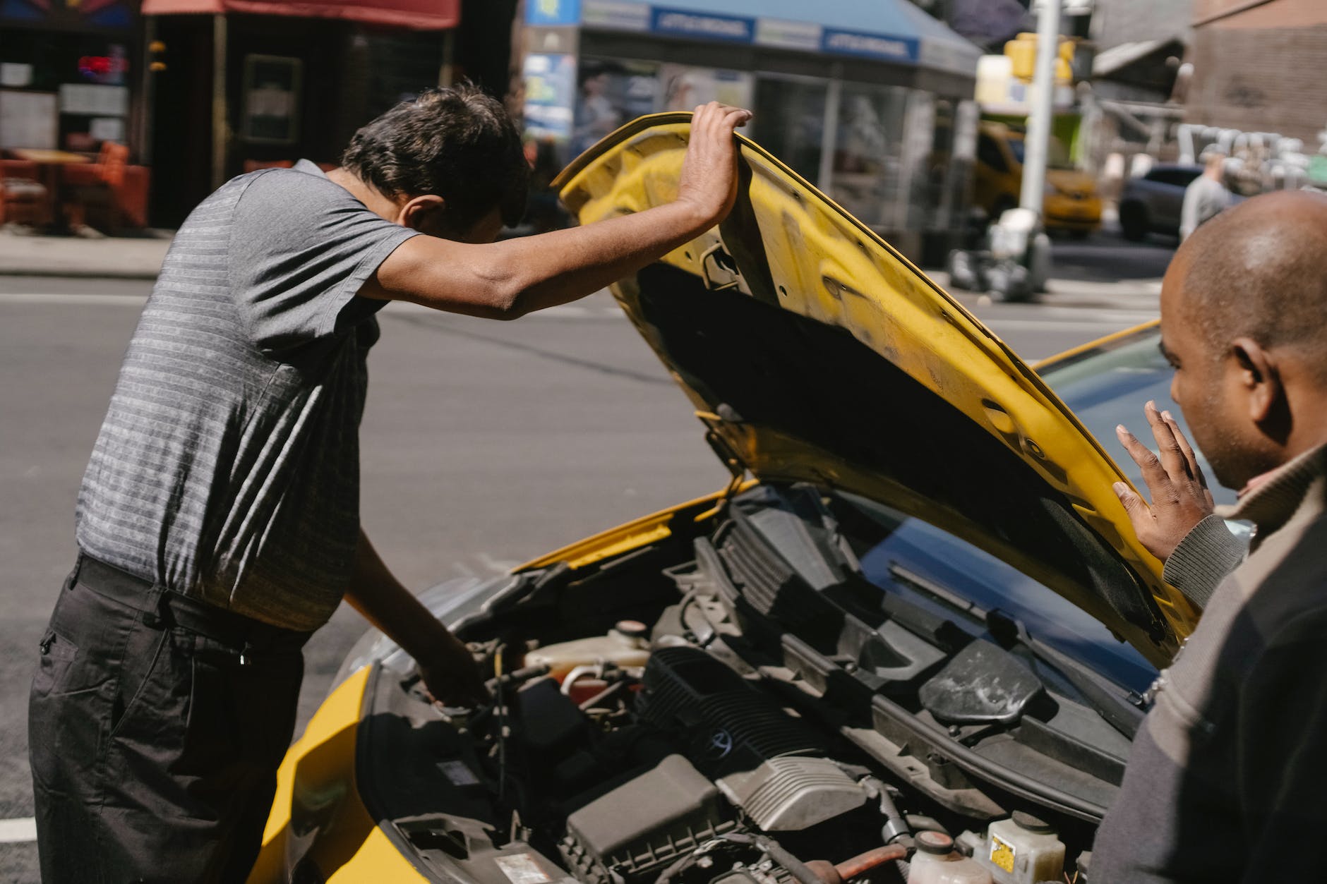 ethnic male drivers coping with trouble in car