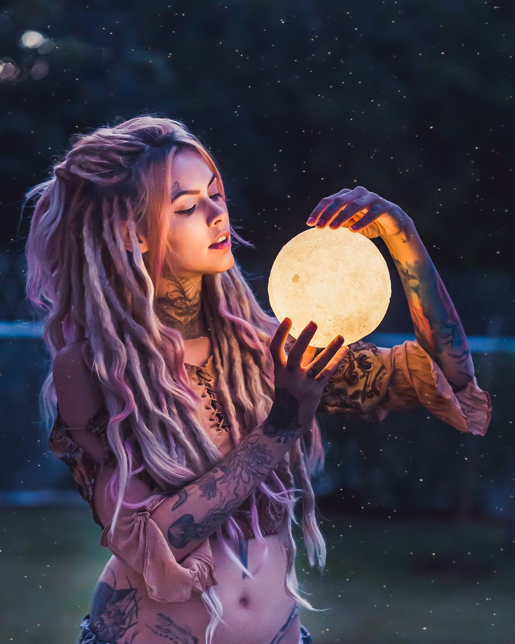 woman with tattoo holding glass globe